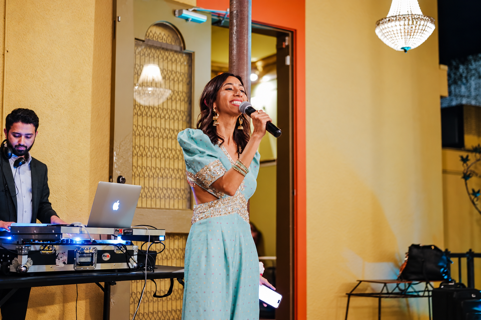 Priya hosting an Indian wedding with a microphone