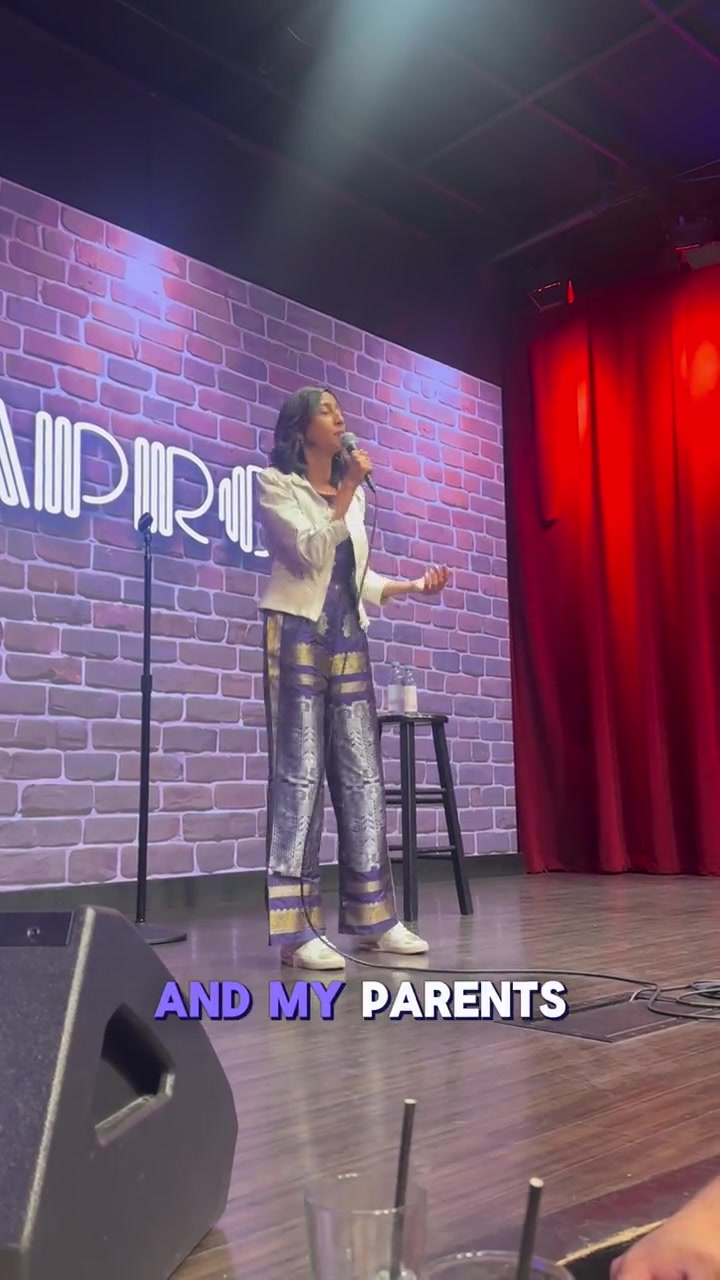 Priya performing stand-up comedy on stage