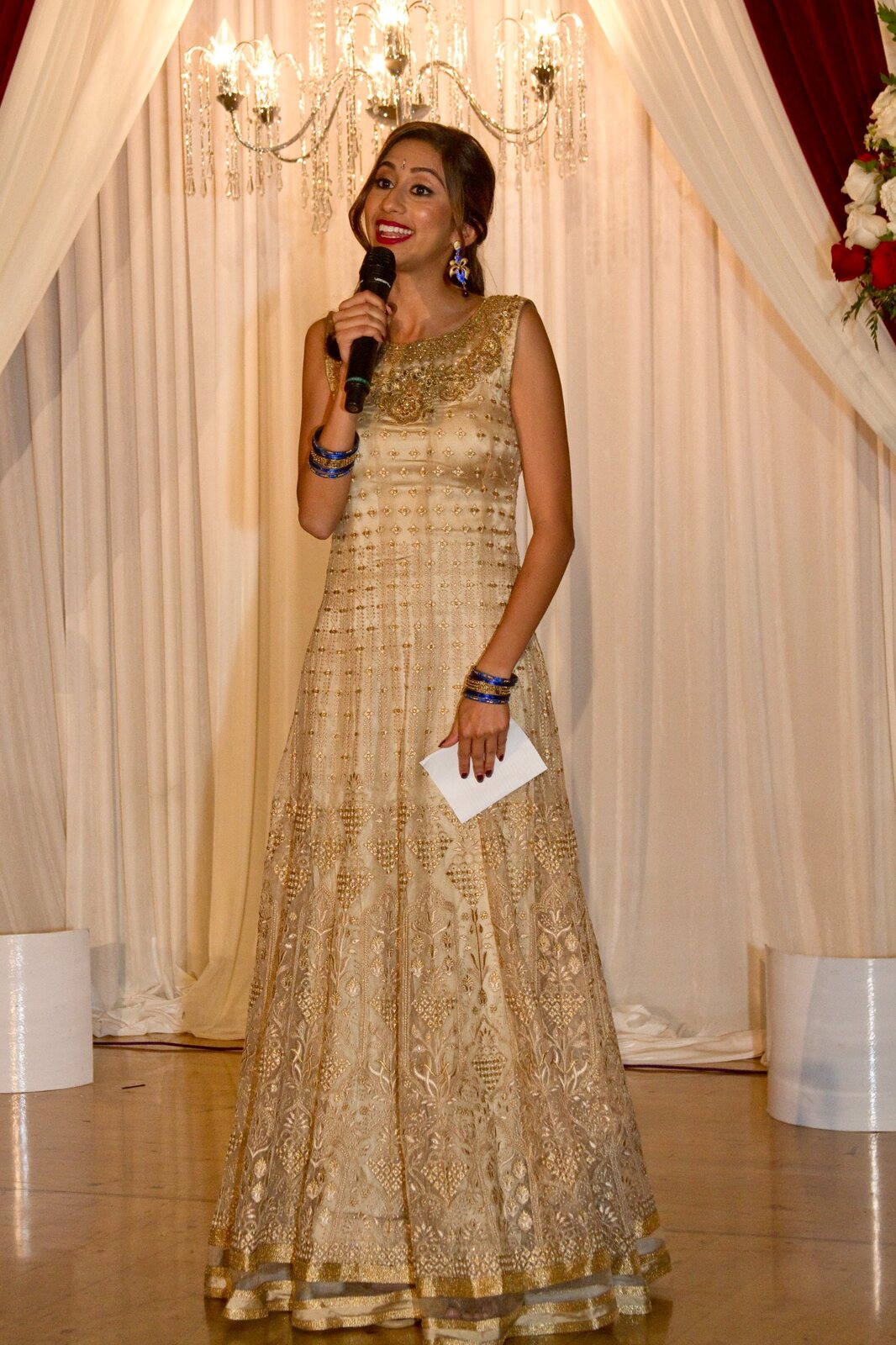 Priya hosting a wedding with a microphone